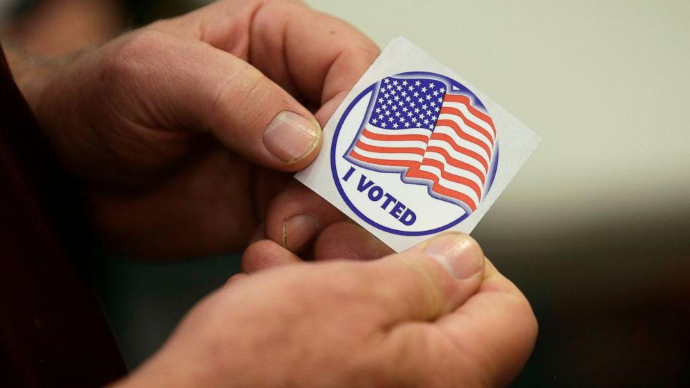 FILE - In this May 8, 2018 file photo, a person holds a sticker after placing his vote at the Durham County Library North Regional in Durham, N.C. A federal judge on Thursday, Jan. 17, 2019, chastised election officials in North Carolina who let a Ko