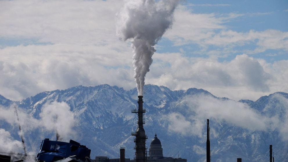 The Utah State Capitol, rear, is shown behind an oil refinery on Thursday, May 12, 2022, in Salt Lake City. A growing number of Republican-led states with economies that rely heavily on fossil fuels are pushing back against shifts in the financial in