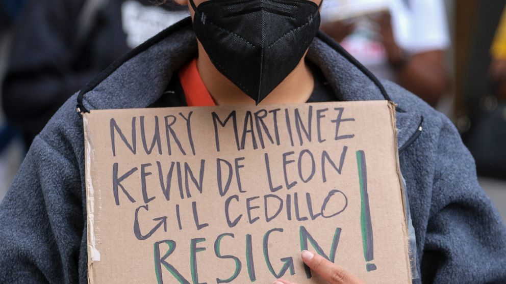 A protester holding a sign protest outside City Hall during the Los Angeles City Council meeting Tuesday, Oct. 11, 2022 in Los Angeles. (AP Photo/Ringo H.W. Chiu)