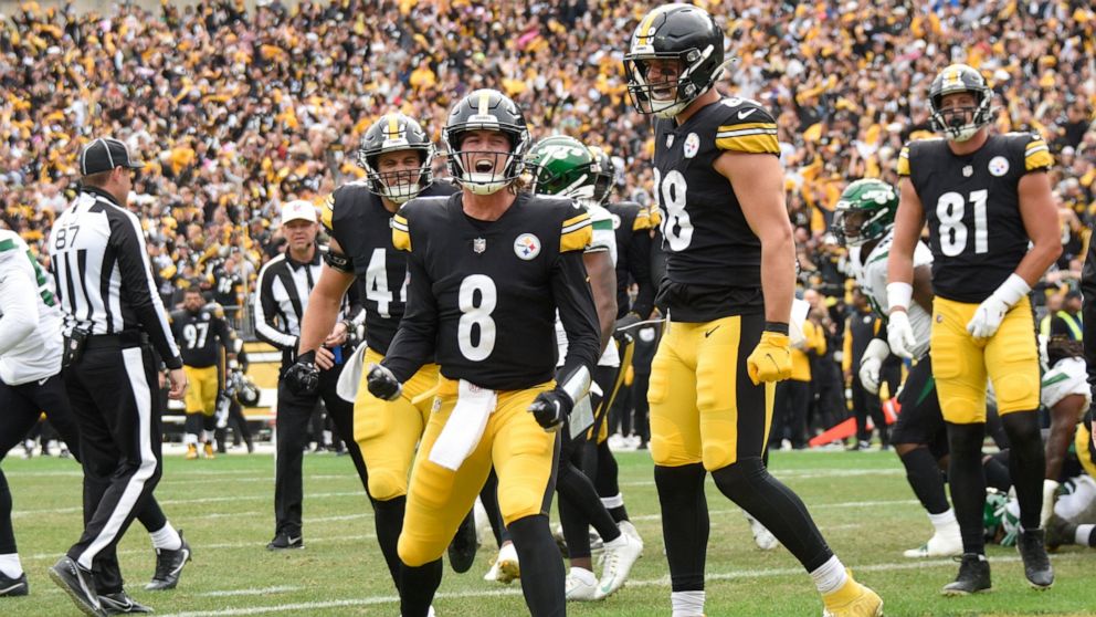 Pittsburgh Steelers quarterback Kenny Pickett (8) celebrates beside teammates after scoring a touchdown against the New York Jets during the second half of an NFL football game, Sunday, Oct. 2, 2022, in Pittsburgh. (AP Photo/Don Wright)