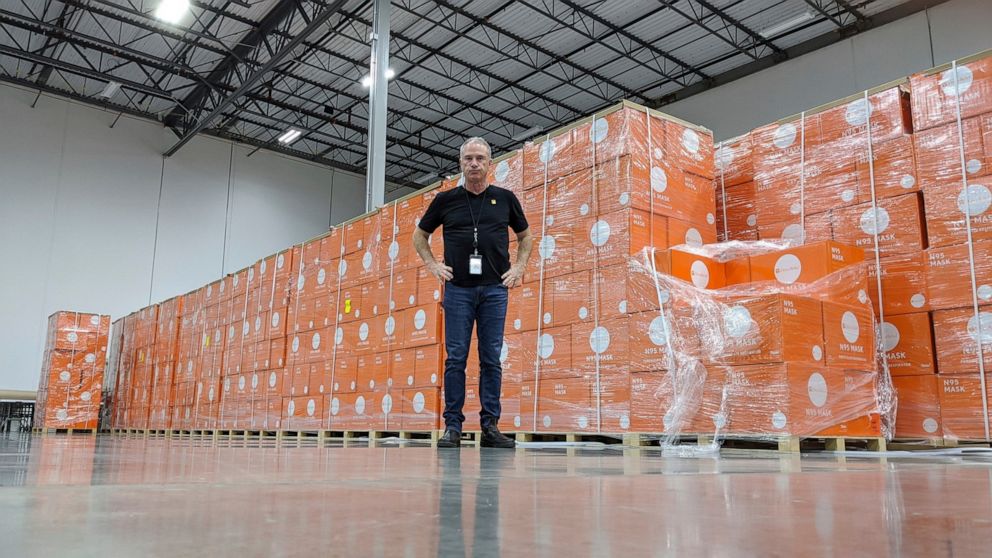 In this image provided by Direct Relief, Direct Relief CEO Thomas Tighe stands in front of boxes of N95 masks at Direct Relief’s Santa Barbara, Calif., warehouse and headquarters in March 2020. Since the war between Russia and Ukraine began in Februa