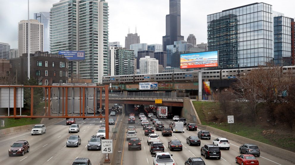FILE - In this March 31, 2021,photo, traffic flows along Interstate 90 highway as a Metra suburban commuter train moves along an elevated track in Chicago. Congress has created a new requirement for automakers: find a high-tech way to keep drunken pe