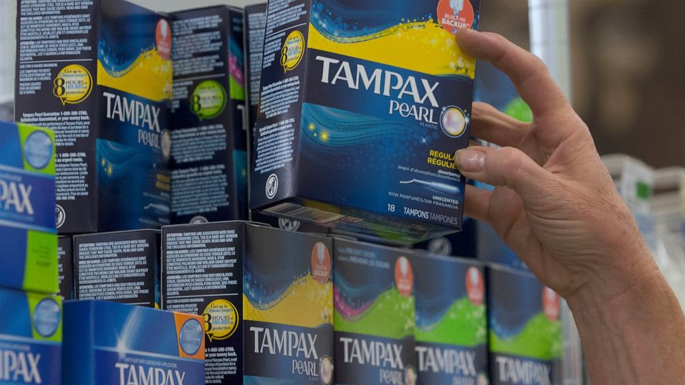 FILE - In this June 22, 2016 file photo, Tammy Compton restocks tampons at Compton's Market, in Sacramento, Calif. California public schools and colleges must stock their restrooms with free menstrual products under a new law signed by Gov. Gavin New