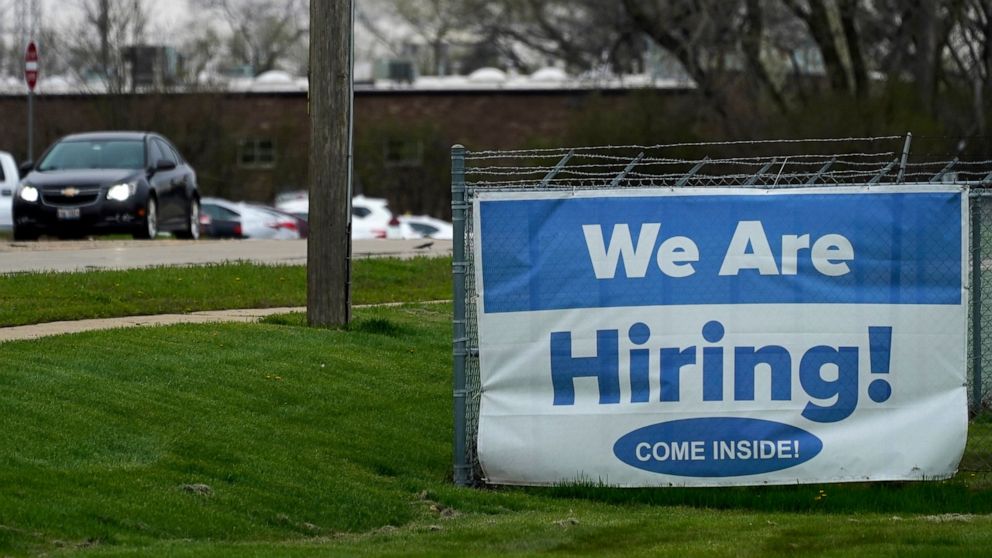 A hiring sign is displayed in Wheeling, Ill., Thursday, May 5, 2022. America’s employers added 428,000 jobs in April, extending a streak of solid hiring that has defied punishing inflation, chronic supply shortages, the Russian war against Ukraine an