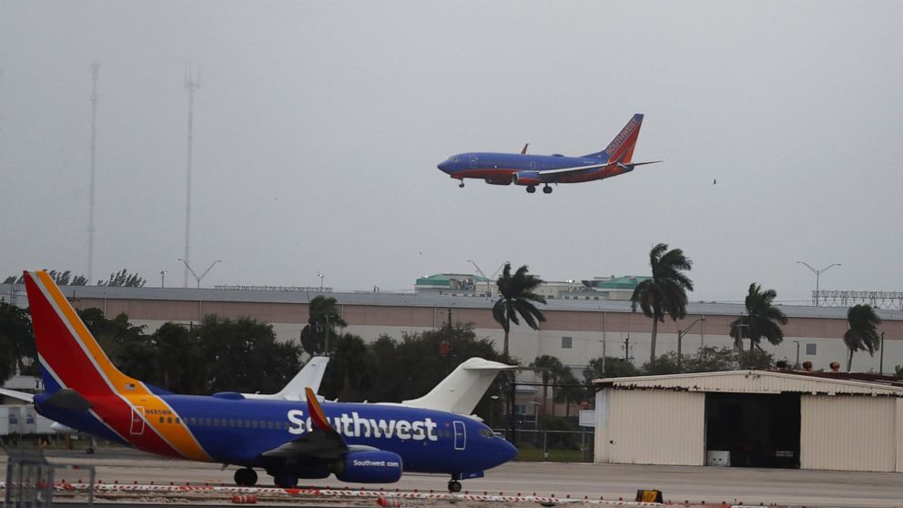 FILE - In this Jan. 10, 2020 file photo, a commercial plane flies into a windy, cloudy sky at the Fort Lauderdale-Hollywood International Airport in Fort Lauderdale, Fla. Federal regulators are temporarily waiving a rule that has been causing airline