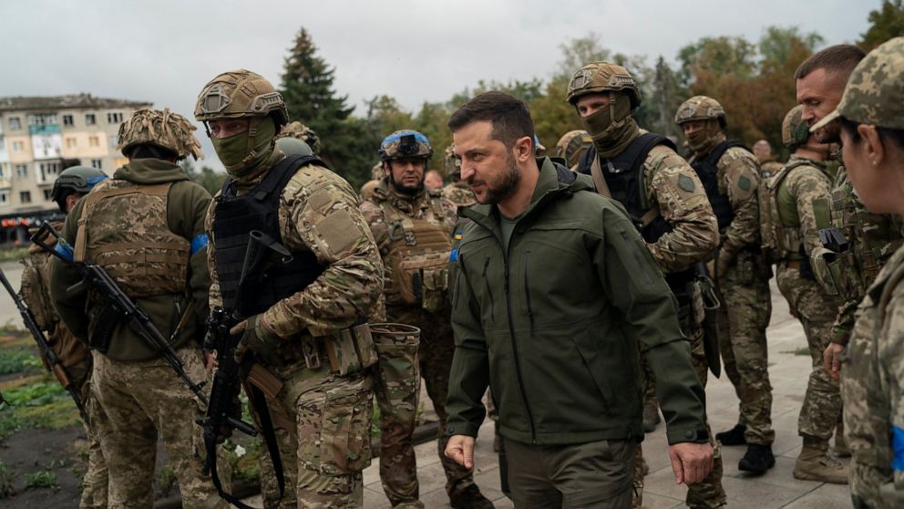 FILE - Surrounded by soldiers the Ukrainian President Volodymyr Zelenskyy attends a national flag-raising ceremony in the freed Izium, Ukraine, Wednesday, Sept. 14, 2022. A tart retort by Zelenskyy to a U.S. offer of help and a call by former U.S. Pr