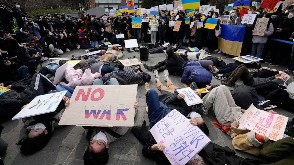 Protesters lie down on the ground during a rally against Russia's invasion of Ukraine, near the Russian Embassy in Seoul, South Korea, Monday, Feb. 28, 2022. (AP Photo/Ahn Young-joon)