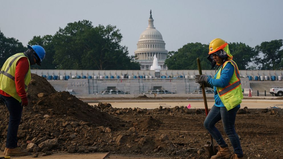 FILE - In this July 21, 2021, file photo workers repair a park near the Capitol in Washington. Senators working on the infrastructure plan hope to have a bill ready to be voted on next week. President Joe Biden has made passing the bipartisan plan a 