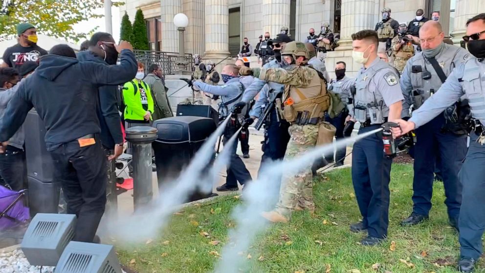 In this image taken from video, Alamance County sheriff's deputies use pepper spray on a crowd of protesters outside the courthouse in Graham, N.C., Saturday, Oct. 31, 2020. A get-out-the vote rally that ended with North Carolina police pepper sprayi
