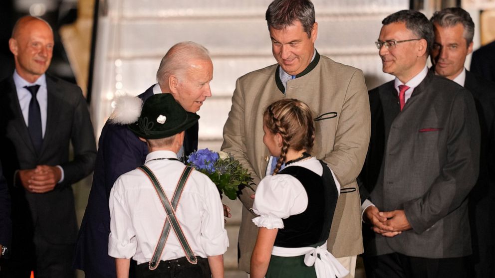 Children Daniela Hauser and Marco Keller greet U.S. President Joe Biden with a bouquet of flowers on his arrival at Franz-Josef-Strauss Airport near Munich, Germany, Saturday, June 25, 2022, ahead of the G7 summit. Bavarian Prime Minister Markus Soed