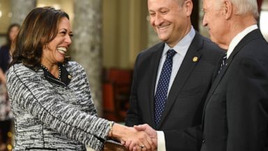 FILE - In this Jan. 3, 2017, file photo, then-Vice President Joe Biden, right, shakes hands with Sen. Kamala Harris, D-Calif., as her husband Douglas Emhoff, watches during a a mock swearing in ceremony in the Old Senate Chamber on Capitol Hill in Wa