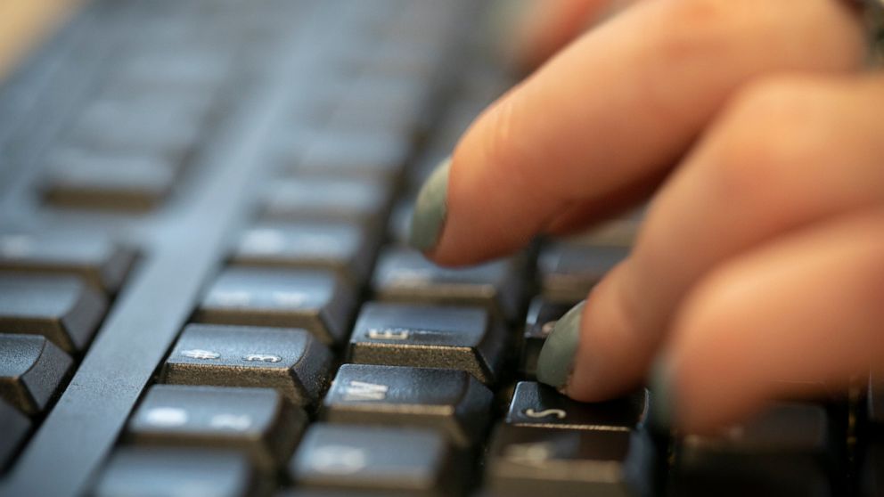 FILE - In this Tuesday, Oct. 8, 2019, file photo, a woman types on a keyboard in New York. Following the disclosure of a global cyberespionage campaign that penetrated multiple U.S. government agencies and private organizations, governments and major