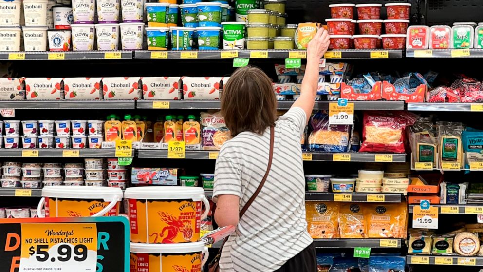 FILE - A customer looks at refrigerated items at a Grocery Outlet store in Pleasanton, Calif., Sept. 15, 2022. More U.S. adults are now feeling financially vulnerable amid high inflation. A new poll from The Associated Press-NORC Center for Public Af