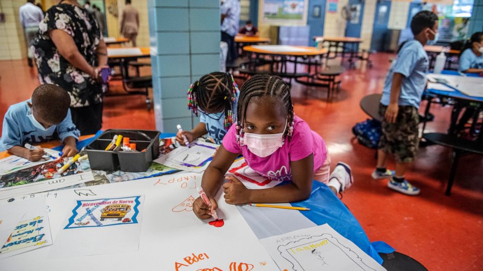 FILE — In this Aug. 17, 2021 file photo, students write and draw positive affirmations on poster board at P.S. 5 Port Morris, an elementary school in The Bronx borough of New York. New York City will phase out its program for gifted and talented stud