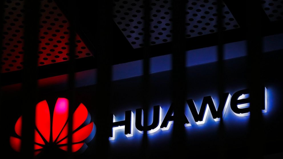FILE - In this March 8, 2019, file photo, A logo of Huawei retail shop is seen through a handrail inside a commercial office building in Beijing. The U.S. government is imposing new restrictions on Chinese tech giant Huawei by limiting its ability to