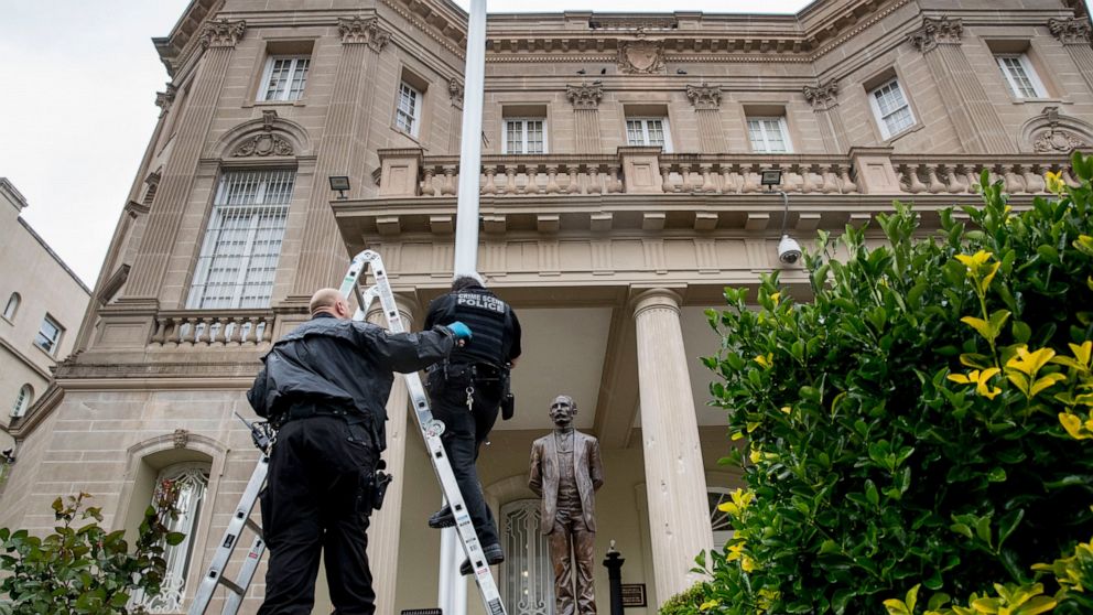 A statue of Cuban national hero Jose Marti is visible behind Secret Service investigators as they look at a bullet hole in the flagpole in front of the Cuban Embassy after police say a person with an assault rifle opened fire, Thursday, April 30, 202