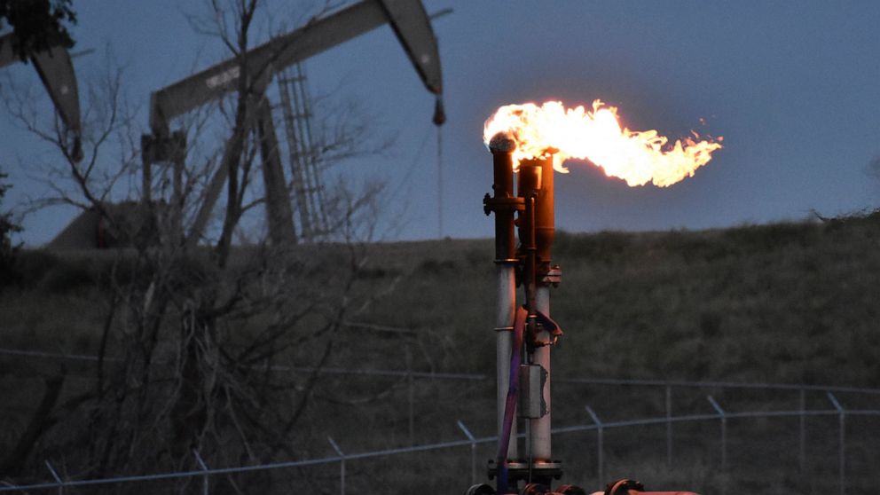 FILE - A flare to burn methane from oil production is seen on a well pad near Watford City, North Dakota, Aug. 26, 2021. A huge social and environmental policy bill passed by House Democrats includes a plan to impose a fee on emissions of methane, a 