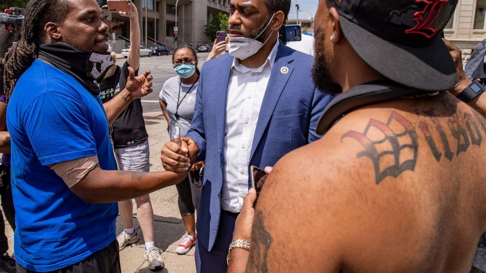 HOLD FOR STORY- In this June 17, 2020 photo U.S. Senate candidate Charles Booker shakes hands with protestors in Louisville, KY. Booker is running against Amy Grath for the senate democratic nomination. (Alton Strupp/Louisville Courier Journal via AP)