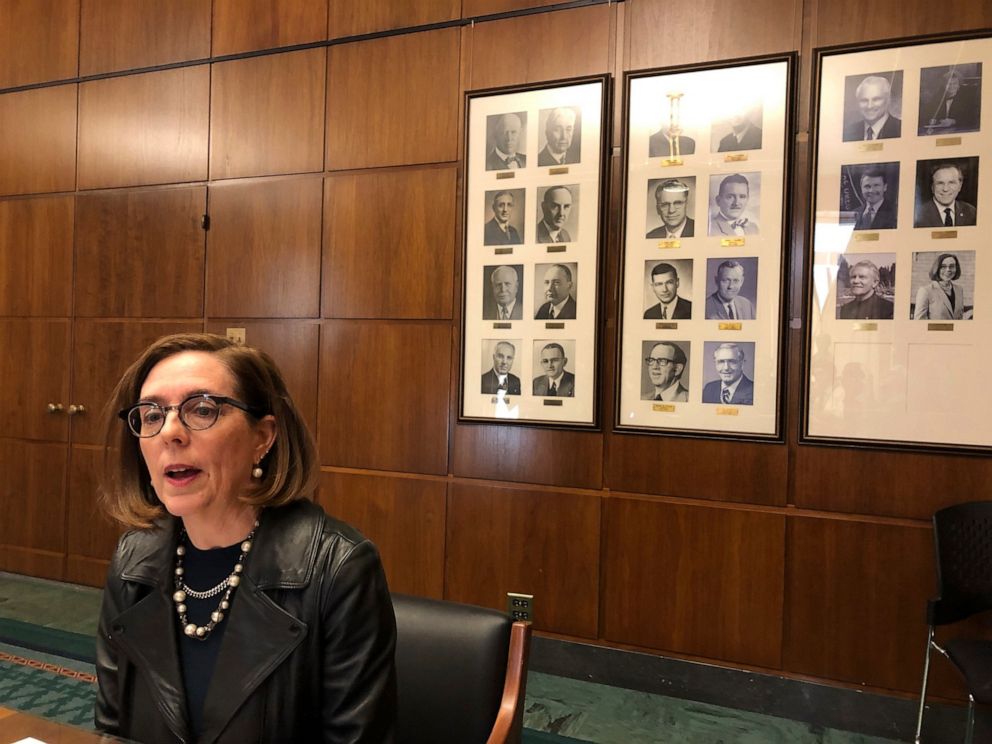 In this Feb. 7, 2019, file photo, Oregon Gov. Kate Brown speaks to reporters in front of pictures of previous state governors in Salem, Ore.