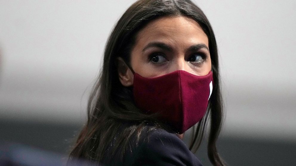 FILE - U.S. Rep. Alexandria Ocasio-Cortez looks round to listen to a question at the COP26 U.N. Climate Summit, in Glasgow, Scotland, Wednesday, Nov. 10, 2021. Ocasio-Cortez has tested positive for COVID-19 and “is experiencing symptoms and recoverin