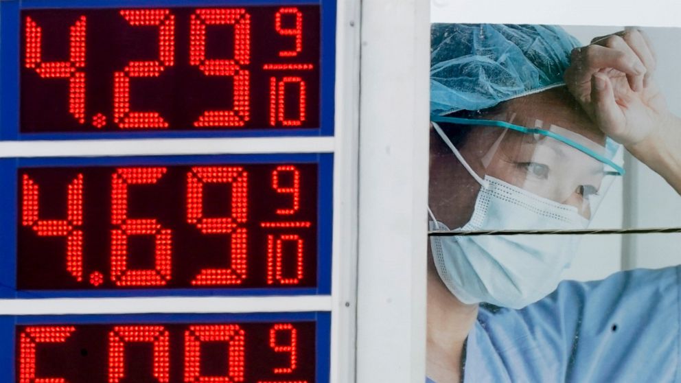 FILE - High gas prices are seen in front of a medical billboard on May 11, 2022, in Milwaukee. Americans are becoming less supportive of punishing Russia for launching its invasion of Ukraine if it comes at the expense of the U.S. economy, a sign of 
