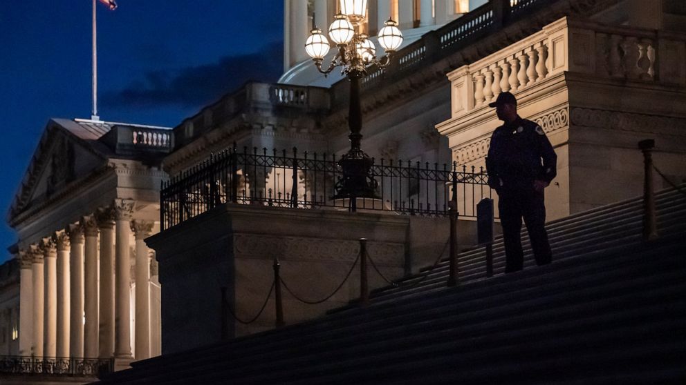 Night falls at the the Capitol in Washington, Thursday, Dec. 2, 2021, with the deadline to fund the government approaching. Republicans in the Senate are poised to stall a must-pass funding bill as they force a debate on rolling back the Biden admini