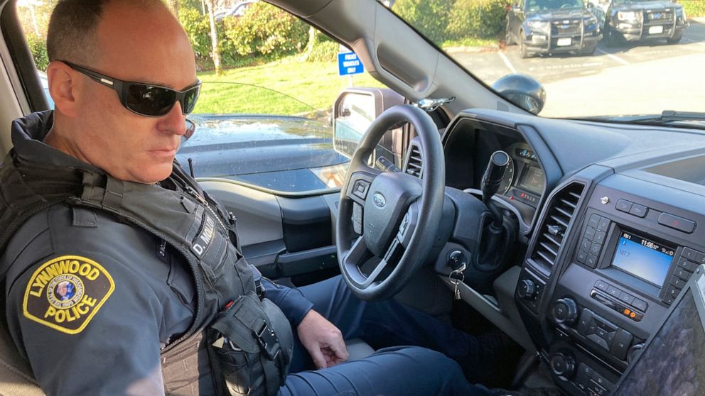 Lynnwood police Officer Denis Molloy works in his vehicle, Wednesday, Nov. 17, 2021, in Lynnwood, Wash. Molloy, of the Lynnwood Police Department's community health and safety section, says that navigating recent police reforms in Washington State ha