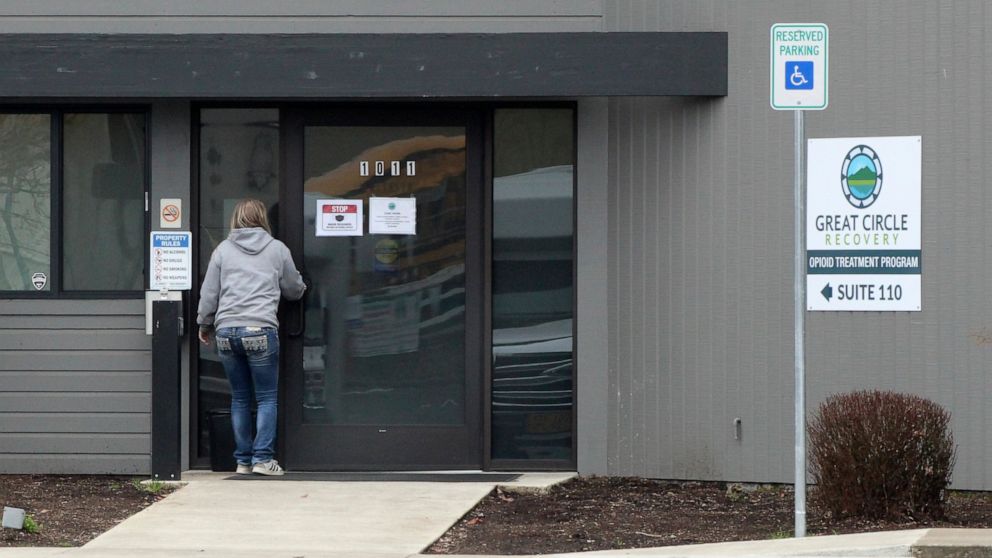FILE—A woman enters the Great Circle drug treatment center in Salem, Oregon, on March 8, 2022. On Thursday, June 2, 2022, Oregon officials and lawmakers said efforts to get millions of dollars in funding to treatment centers and related services as p
