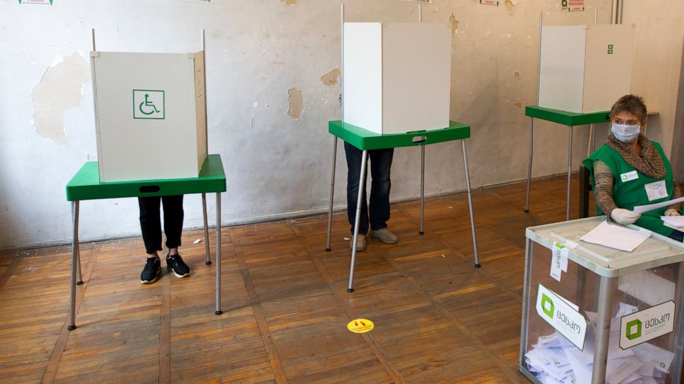 Voters fail in their ballots in polling booths at a polling station during the parliamentary elections in Tbilisi, Georgia, Saturday, Oct. 31, 2020. The hotly contested election between the Georgian Dream party, created by billionaire Bidzina Ivanish