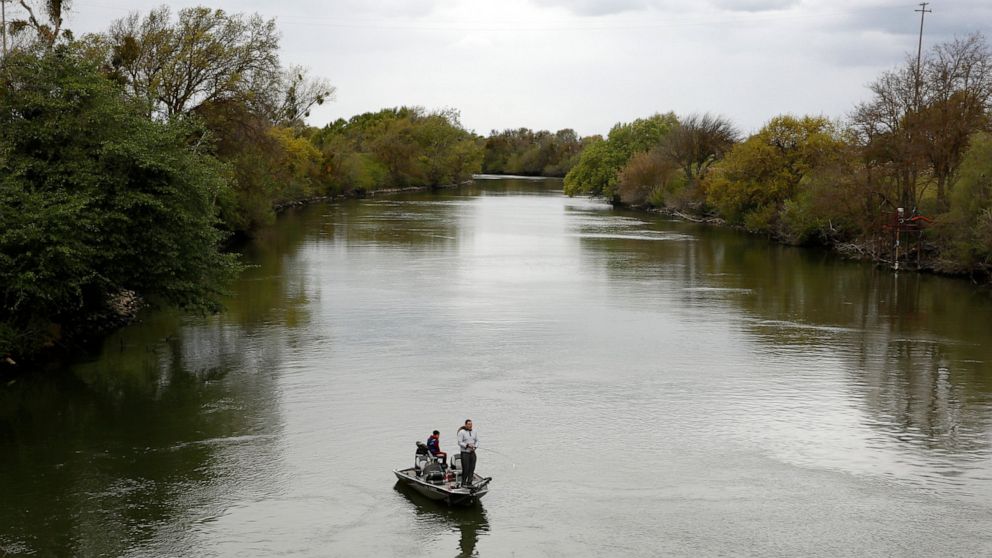 FILE - People fish in the Sacramento-San Joaquin River Delta's Elk Slough near Courtland, Calif., Tuesday, March 24, 2020. A proposal in the California state Senate aims to keep more water in California's rivers and streams to benefit endangered spec