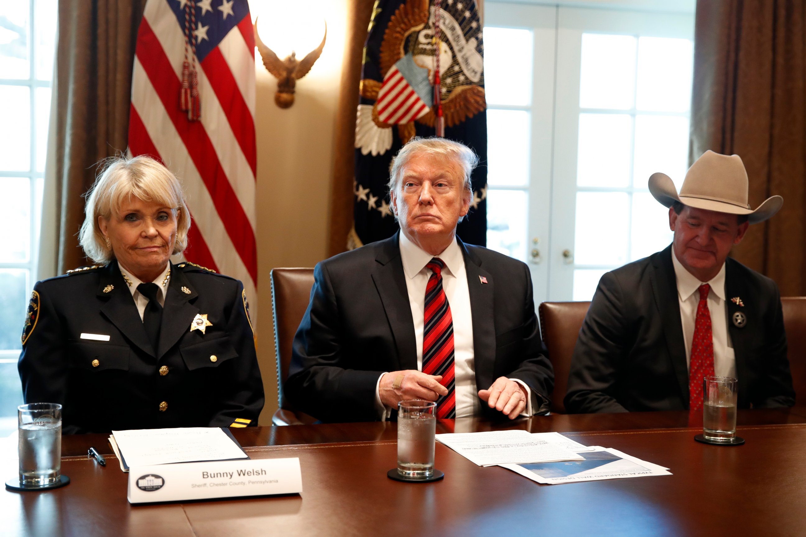 President Donald Trump, with Carolyn "Bunny" Welsh, sheriff of Chester County, Pa., left, and AJ Louderback, sheriff of Jackson County, Texas, attends a roundtable discussion on border security with local leaders, Friday Jan. 11, 2019.