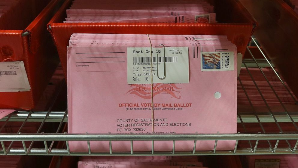 FILE - In this Oct. 22, 2018, file photo, mail-in ballots are placed in bins to be processed after arriving at the Sacramento County Registrar of Voters in Sacramento, Calif. The California Assembly on Thursday, June 18, 2020, sent Gov. Gavin Newsom 