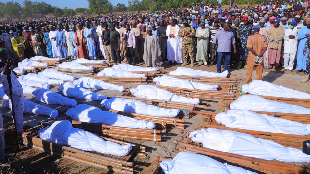 People attend a funeral for those killed by suspected Boko Haram militants in Zaabarmar, Nigeria, Sunday, Nov. 29, 2020. Nigerian officials say suspected members of the Islamic militant group Boko Haram have killed at least 40 rice farmers and fisher