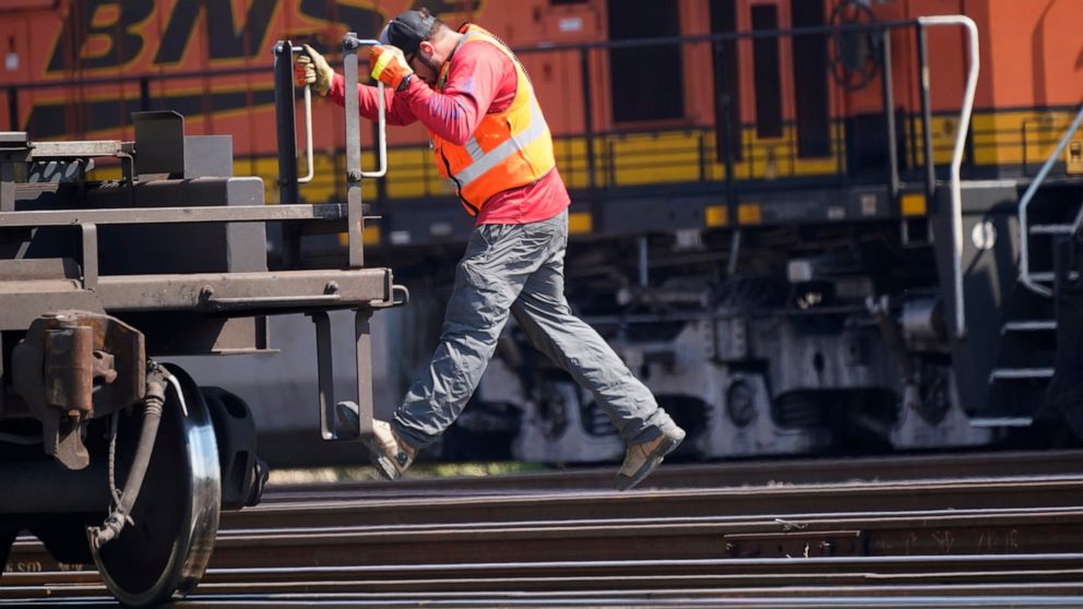 A worker rides a rail car at a BNSF rail crossing in Saginaw, Texas, Wednesday, Sept. 14, 2022. Business and government officials are preparing for a potential nationwide rail strike at the end of this week while talks carry on between the largest U.