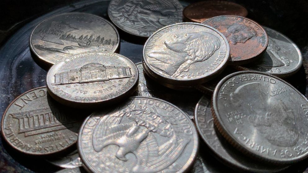 Quarters, nickels, dimes and pennies are held a bowl Thursday, March 31, 2022, in Tigard, Ore. Retailers, laundromats and other businesses that rely on coins want Americans to empty their piggy banks and look under couch cushions for extra change and