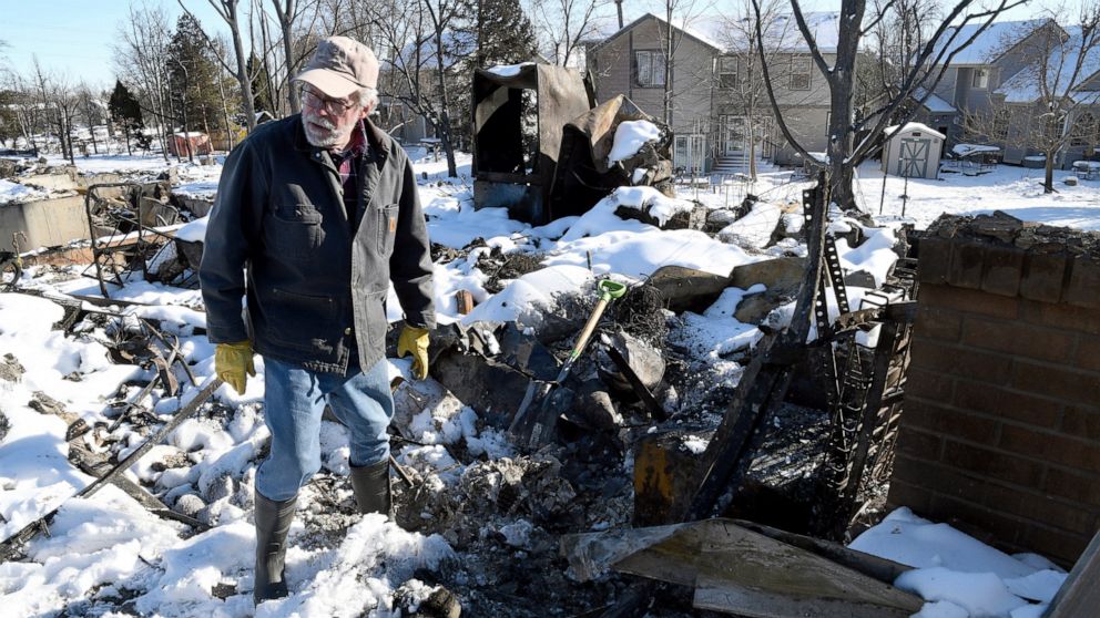 FILE - Rex Hickman sifts through the rubble of his burned home in Louisville, Colo., Sunday, Jan. 2, 2022. Some homeowners recovering from Colorado's most destructive wildfire in history, which decimated entire neighborhoods near Denver late last yea