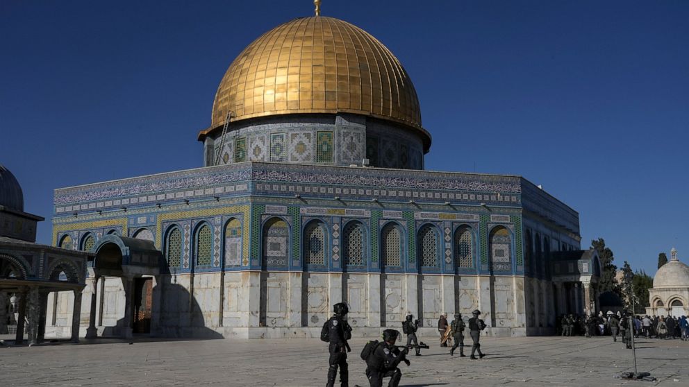FILE - Israeli security forces take position during clashes with Palestinians demonstrators in front of the Dome of the Rock shrine at the Al Aqsa Mosque compound in Jerusalem's Old City, April 15, 2022. In the weeks before a rare confluence of major