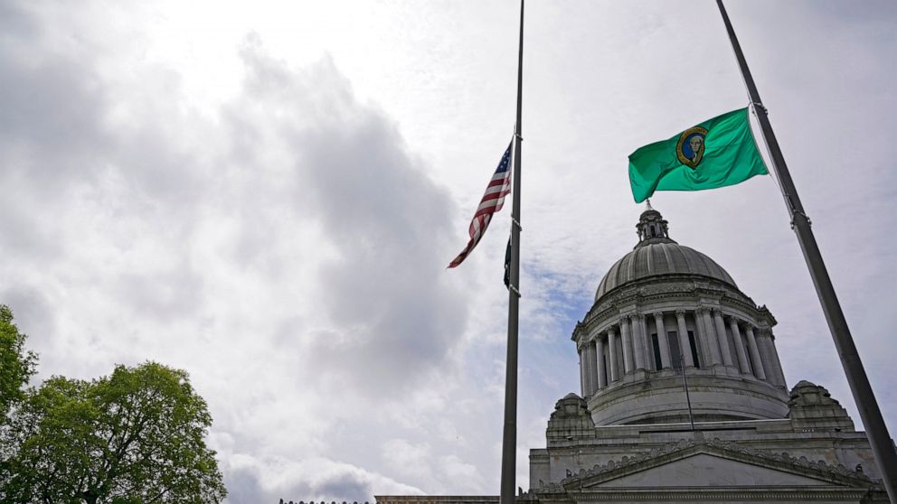 The U.S. and Washington state flags fly at half-staff in front of the Legislative Building at the Capitol in Olympia, Wash., Wednesday, May 25, 2022, in memory of the victims of the mass shooting in Uvalde, Texas. Washington Gov. Jay Inslee was quick