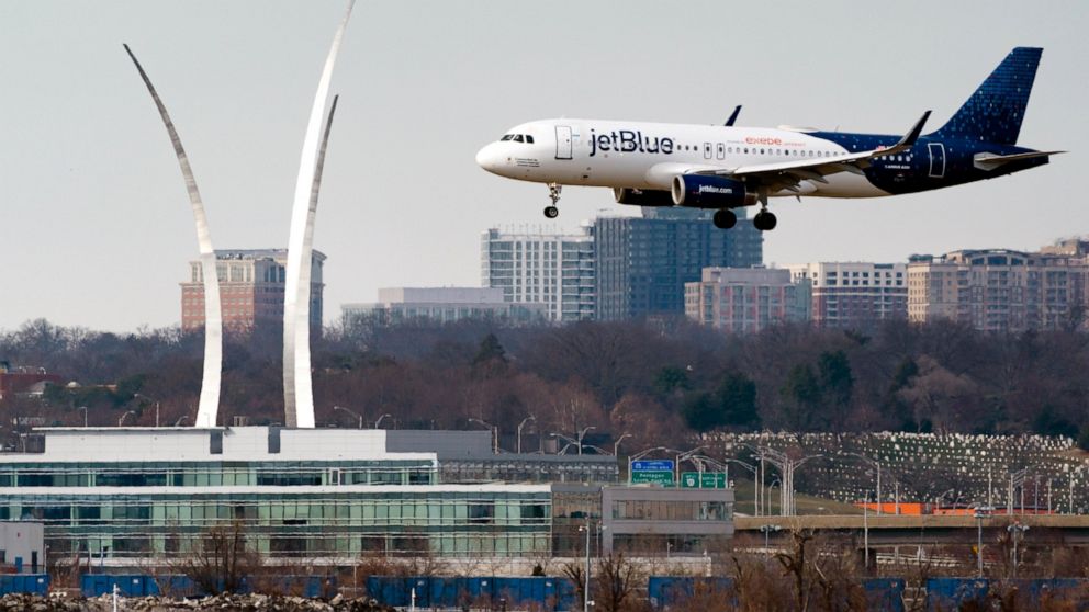 FILE - A JetBlue passenger flight lands at Reagan Washington National Airport in Arlington, Va., across the Potomac River from Washington, Wed., Jan. 19, 2022. On Friday, June 17, 2022, federal regulators said Verizon and AT&T will delay part of thei