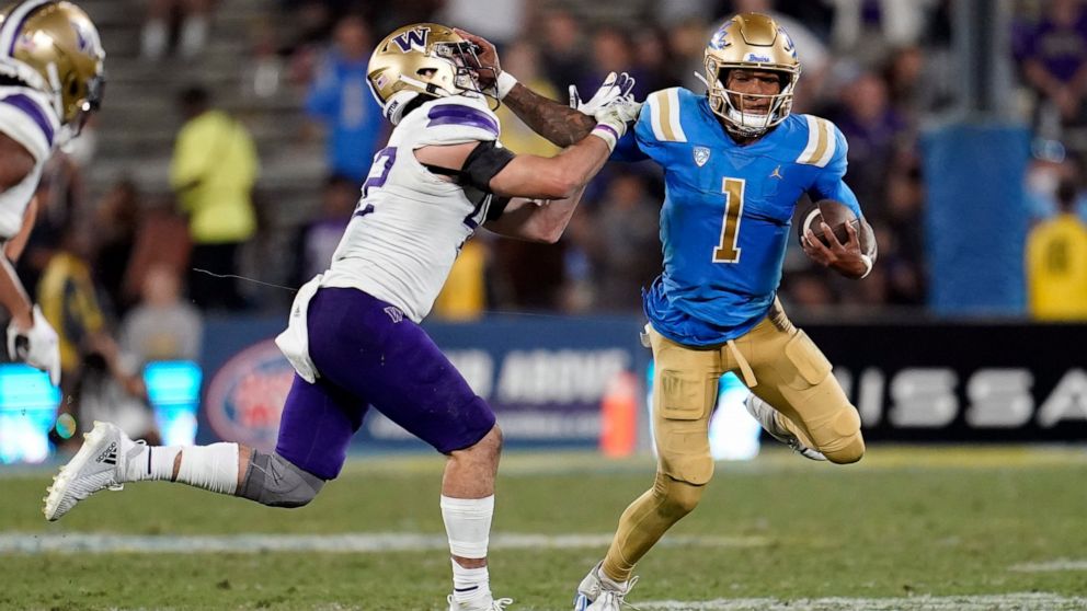 UCLA quarterback Dorian Thompson-Robinson (1) stiff-arms Washington linebacker Carson Bruener during the second half of an NCAA college football game Friday, Sept. 30, 2022, in Pasadena, Calif. (AP Photo/Marcio Jose Sanchez)