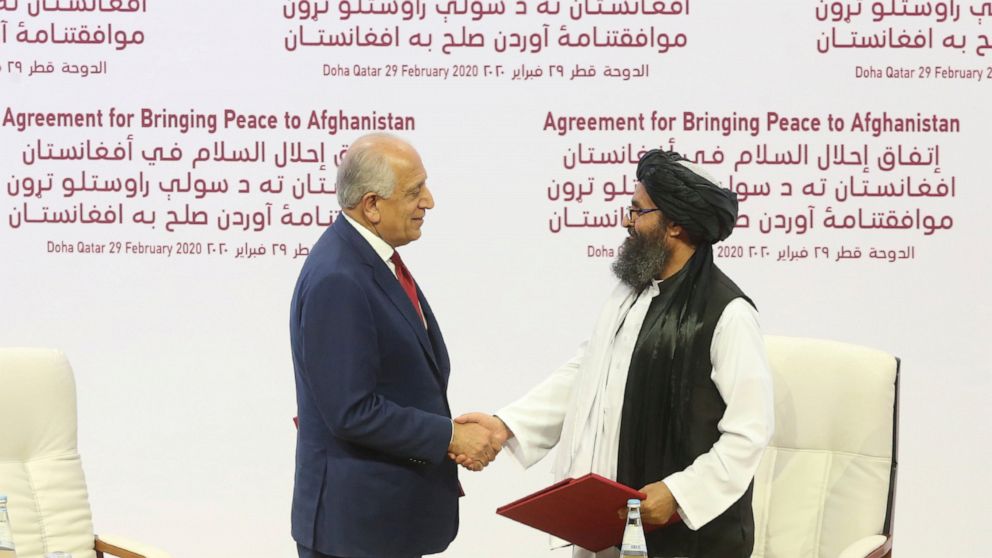 FILE - In this Feb. 29, 2020, file photo, U.S. peace envoy Zalmay Khalilzad, left, and Mullah Abdul Ghani Baradar, the Taliban group's top political leader shack hands after signing a peace agreement between Taliban and U.S. officials in Doha, Qatar.