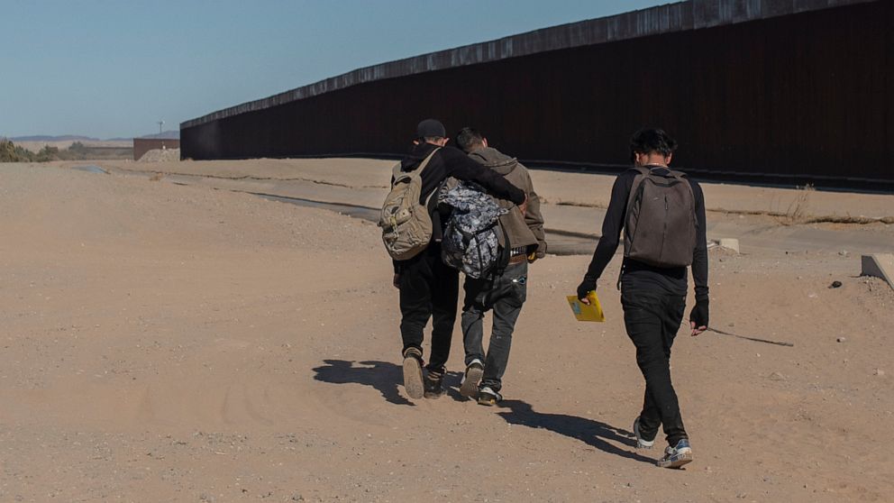 FILE - Nicaraguan migrants walk on the US-Mexico border, in Algodones, Baja California, Mexico, Dec. 2, 2021. The group walked into the U.S. and turned themselves over to the border patrol asking for asylum. The Biden administration has a draft plan 
