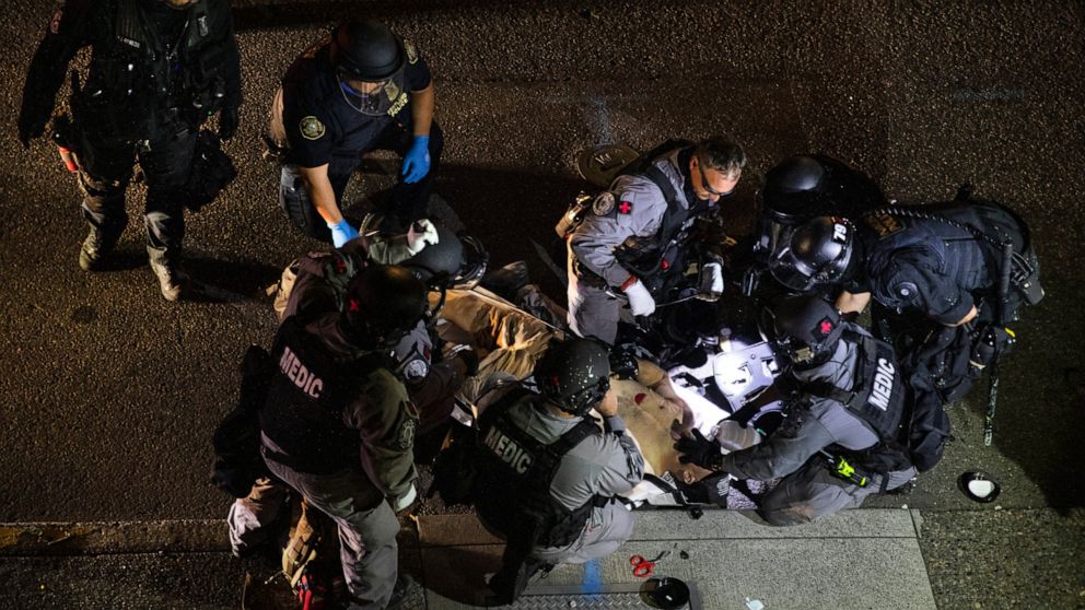 A man is treated by medics after being shot Saturday, Aug. 29, 2020, in Portland, Ore. Fights broke out in downtown Portland as a large caravan of supporters of President Donald Trump drove through the city, clashing with counter-protesters. (AP Phot