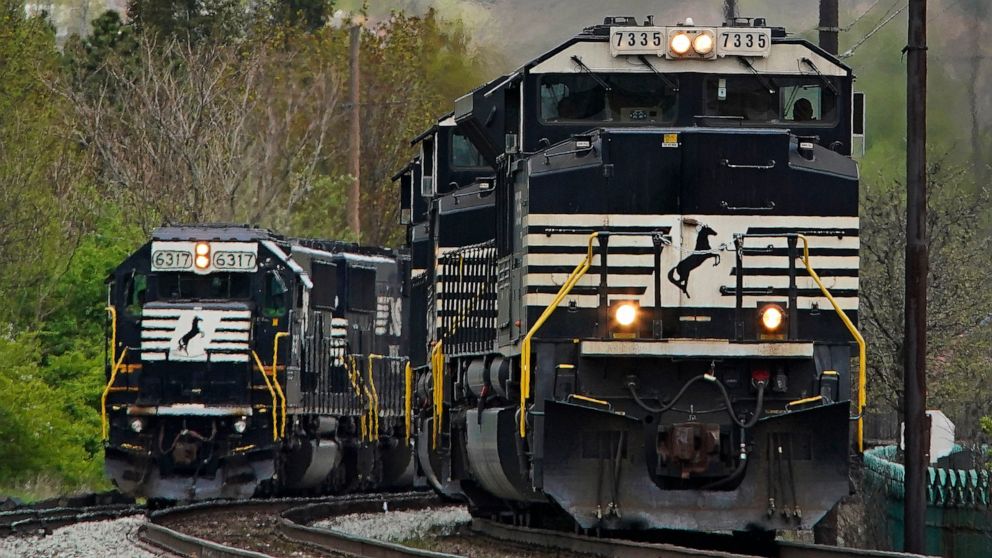 FILE - A Norfolk Southern freight train passes a train on a siding as it approaches a crossing in Homestead, Pa., Wednesday, April 27, 2022. Three of the 12 unions negotiating with the nation's biggest freight railroads reached a tentative deal, Mond