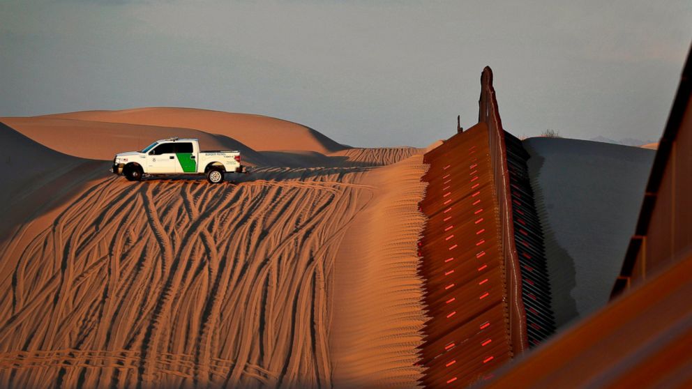 FILE - In this July 18, 2018 file photo, a U.S. Customs and Border Patrol agent patrols a section of floating fence at sunset that runs through Imperial Sand Dunes along the international border with Mexico in Imperial County, Calif. President Donald