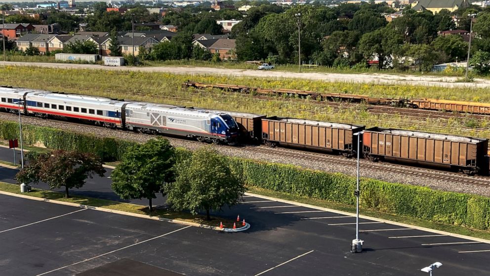 An Amtrak passenger train and a freight train head northbound towards downtown Chicago Wednesday, Sept. 14, 2022, in Chicago. Business and government officials are preparing for a potential nationwide rail strike at the end of this week while talks c