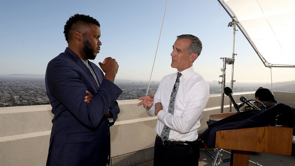 FILE - In this April 19, 2021 file photo, Los Angeles Mayor Eric Garcetti, right, talks with Michael Tubbs, founder of Mayors for a Guaranteed Income, after holding his annual State of the City address from the Griffith Observatory, in Los Angeles. I