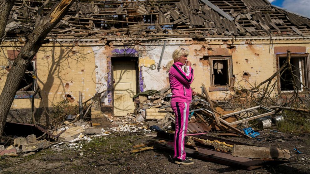 Iryna Martsyniuk, 50, stands next to her house, heavily damaged after a Russian bombing in Velyka Kostromka village, Ukraine, Thursday, May 19, 2022. Martsyniuk and her three young children were at home when the attack occurred in the village, a few 