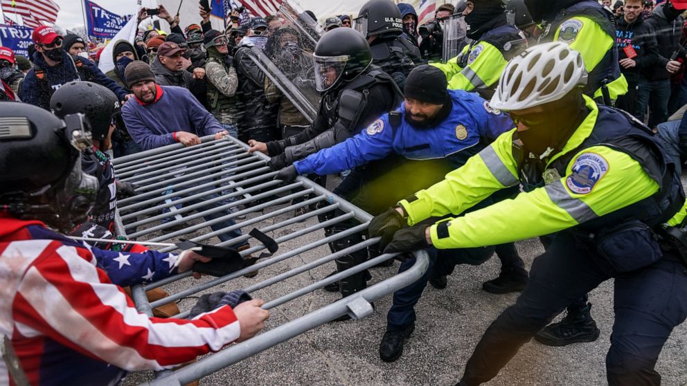 FILE - In this Jan. 6, 2021, file photo violent insurrectionists loyal to President Donald Trump supporters try to break through a police barrier at the Capitol in Washington. A month ago, the U.S. Capitol was besieged by Trump supporters angry about