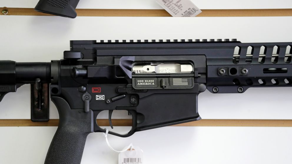 FILE - In this photo taken Oct. 2, 2018, a semi-automatic rifle, with "God Bless America" imprinted on it, is displayed for sale on the wall of a gun shop in Lynnwood, Wash. A dozen county sheriffs in Washington state are refusing to enforce restrict